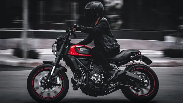 Motorista con chaqueta de cuero en marcha